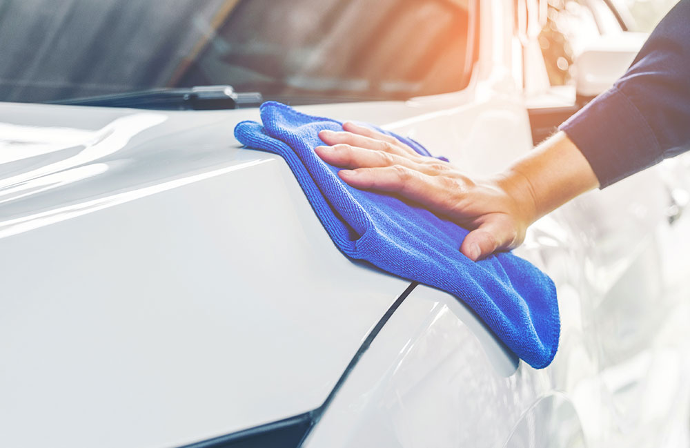 autopflege-aussen Ein Auto wird mit einem Tuch außen geputzt